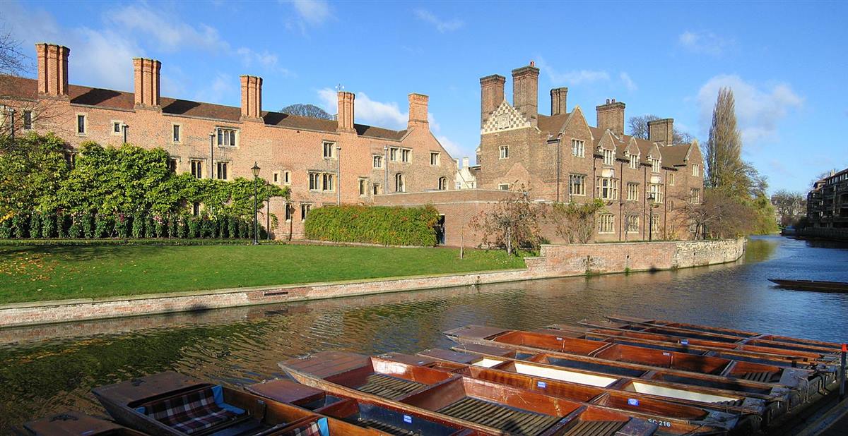 Magdalene College's riverside buildings beside the River Cam, with punts moored in the foreground